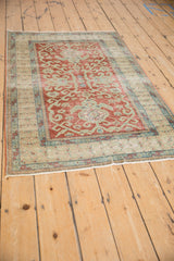 Distressed cherry red Caucasian rug showing even wear, turtle and wave motifs.