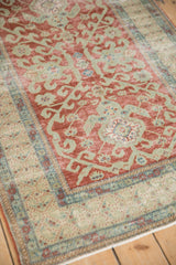 Distressed vintage Caucasian rug with cherry red hook and latch motif and continuous plant border.