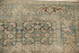 Faded Herati motif on distressed Persian Bijar rug, dusty blue, beige, and visible wear.