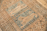 Close-up of distressed Qashqai rug; abstract tribal patterns in dusty blue, ivory, and coffee brown.