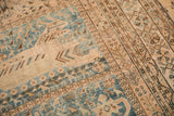 Close-up: Vintage distressed Qashqai rug, softened pile, geometric blue and ivory motifs.