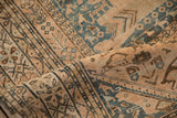 Textural distressed pile of a Qashqai rug in ivory, dusty blue, and coffee brown.