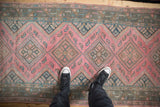 Distressed vintage Malayer runner with dusty fuchsia diamond medallions and mahimahi motifs.