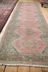 Distressed Malayer runner with faded fuchsia, teal diamond and quatrefoil leaf patterns.