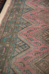 Distressed pile of Malayer runner, featuring geometric patterns in dusty fuchsia and teal.