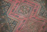 Dusty fuchsia and teal tones of a distressed Malayer runner's worn geometric pile.