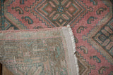 Worn dusty fuchsia pile, faint foundation, and finished edge detail of vintage Malayer runner.