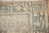 Intricate geometric vine and tree motifs on the corner border of a vintage distressed Karaja rug.