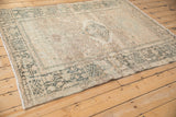 Angled view of a vintage Karaja rug showing its distressed diamond medallion and geometric border.