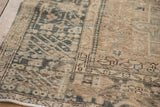 Intricate geometric border and worn, low pile on a distressed vintage Persian Karaja rug corner.