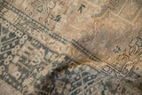 Texture detail of a distressed vintage Karaja rug with a low pile in sand and dusty teal.