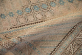 Distressed vintage Afshar rug texture with geometric starbursts, dusty blues, and soft ivory tones.