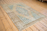 Worn borders and dusty blue palmette medallion detail on distressed Mazlaghan rug.
