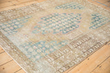 Distressed Mazlaghan rug showing visible foundation, pale blue palmette motifs, and geometric brown border.