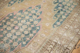 Textured blue lattice palmette, serrated contour, and beige floral motifs on this distressed Mazlaghan rug.