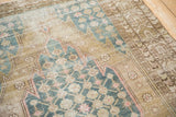 Vintage Mazlaghan rug with visible wear, blue palmette lattice, and ochre serrated contour.