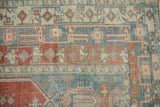 Detail of faded sky blue and madder red geometric borders with diamond-shaped motifs.