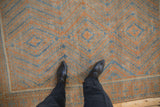Distressed Belouch rug's faded sapphire blue, terracotta geometric hook and latch patterns.