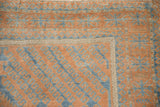 Distressed vintage Belouch rug corner, geometric hook and latch motifs in terracotta and sapphire blue.