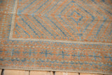 Detail of distressed terracotta and sapphire geometric patterns on vintage Belouch rug.