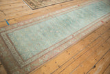 Distressed Karabagh runner showing soft turquoise field, red accents, and salmon serpent border.