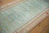 Distressed Karabagh runner in pale turquoise, showing wear and dusty ruby red serpent border.