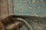 Distressed Karabagh runner showcasing pale turquoise plant motifs and ruby red serpent border.