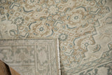 Distressed Sparta rug texture with ecru, brown, and blue pattern, revealing its hand-knotted foundation.