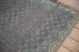 Corner of a distressed antique Malayer rug showing its Boteh lattice pattern and reduced outer border.
