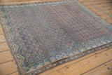 Angled view of a distressed Malayer rug highlighting its allover Boteh lattice and time-softened patina.
