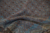 Folded corner of an antique Malayer rug showing the textured low pile and boteh lattice design.