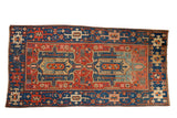 Antique Heriz rug featuring a vivid sapphire blue and ruby red geometric double medallion.