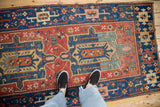 Antique Heriz rug's sapphire blue, ruby red geometric field, vibrant abrash, and storied even wear.