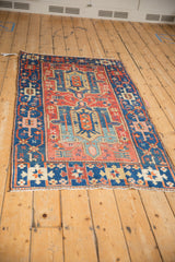 Antique Heriz rug with an asymmetric double medallion, heavy abrash, geometric motifs, and mostly even pile wear.