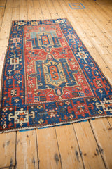 Heriz rug lower corner showing ivory fringe, and sapphire blue, brick red geometric border.