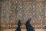Even wear across the low pile of a vintage Malayer rug with a geometric fish design.