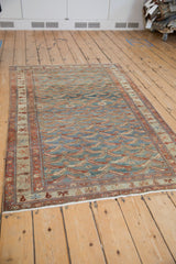 Vintage Persian Malayer rug showing its allover fish design in distressed dusty blue and ruby red.