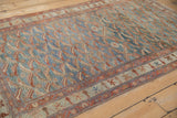 Angled view of the vintage Malayer rug's allover fish motif and time-softened texture.