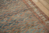 Textured low pile of a distressed Persian rug with a dusty blue and ruby fish pattern.