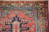 Hand-knotted Heriz rug runner's detailed geometric main border, showing brick red, teal, and camel.