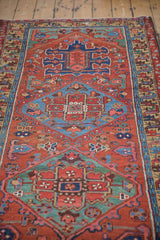 Antique Heriz runner detail showing brick red ground, curvilinear vines, and hand-knotted pile texture.