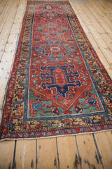 Antique Heriz rug runner's main border with stylized camel, blue, and red geometric animal motifs.