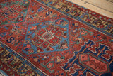 Antique Heriz runner reveals geometric medallion in sapphire blue and brick red floral motifs.