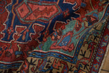 Folded antique Heriz runner detail with teal border and playful serpent-like vine motif.