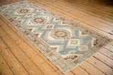 Angled full-length view of a vintage Malayer runner with a central column of medallions.