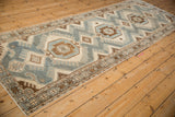 Angled view of the vintage Malayer runner's interconnected medallions and finned details.