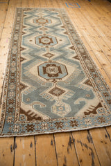 A full length perspective view of the distressed Persian Malayer runner's interconnected medallions.