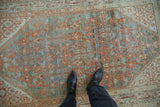Distressed antique Serbend rug pile with dusty teal, terracotta floral motifs and visible foundation.
