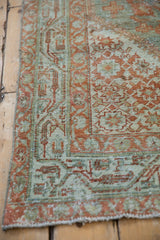 Patina on the corner of an antique Serbend rug, revealing terracotta and teal floral motifs.