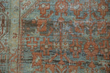 Distressed Serbend rug texture, showing terracotta, teal, and visible foundation.